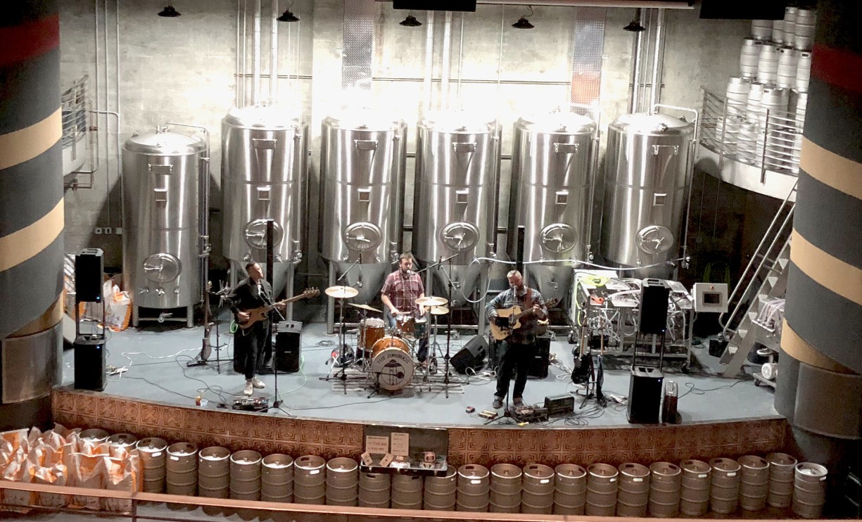 Live music at the Times Theater Live band playing on stage in front of the brewery tanks at the Times Theater