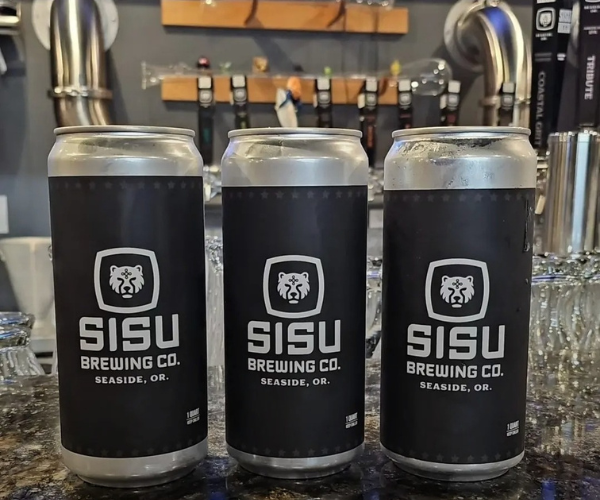 Three Sisu Brewing Co beer cans lined up in front of the taproom taps