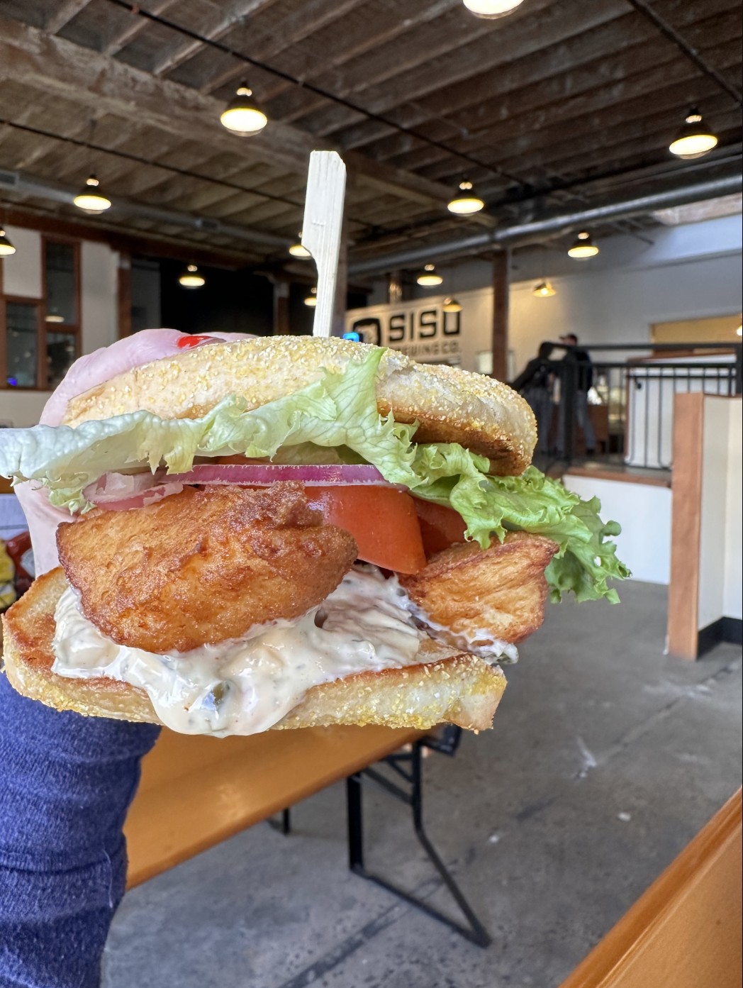 Fried chicken sandwich with lettuce and tomato at Sisu Brewing Astoria