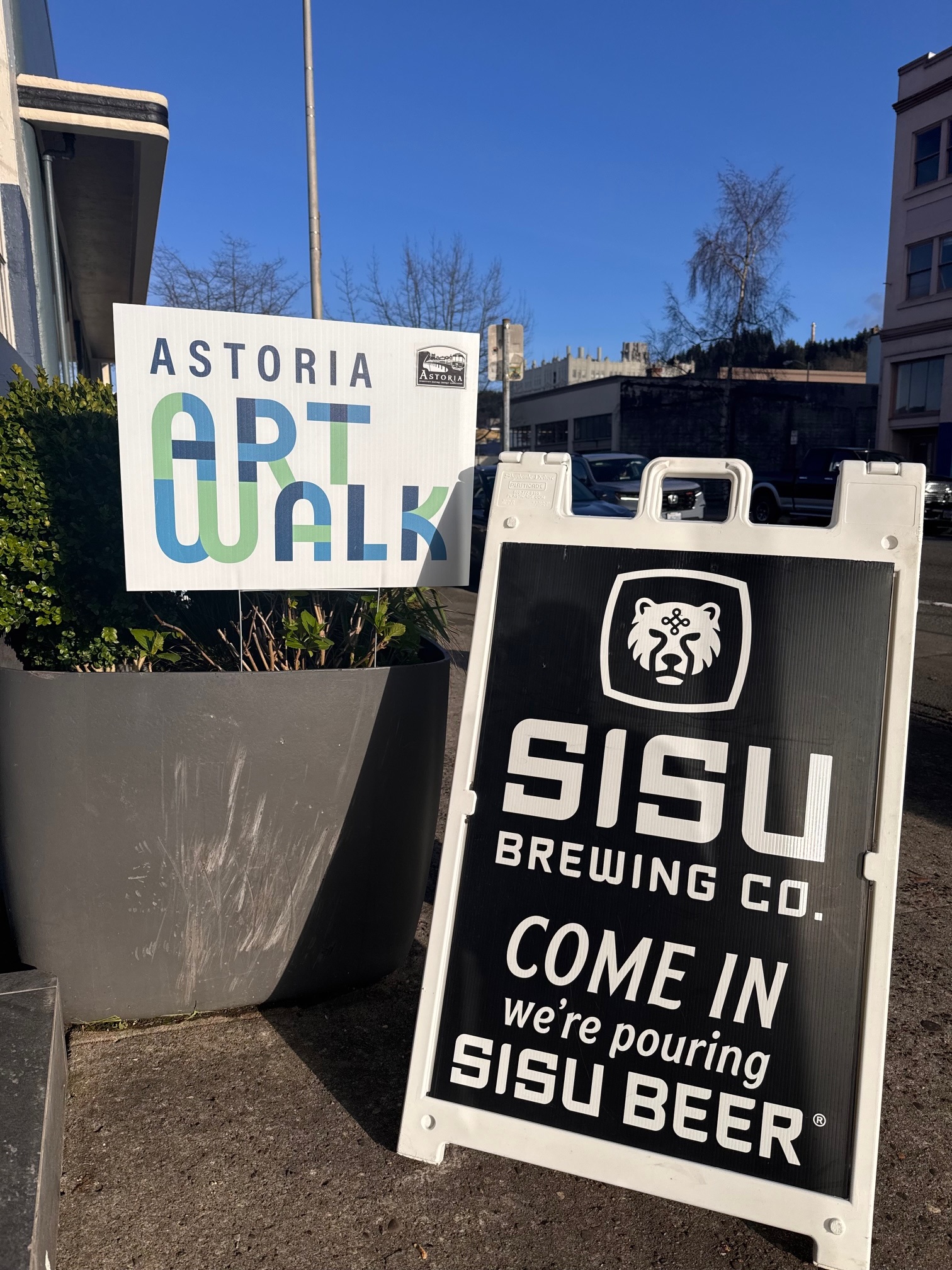 Astoria Art Walk sign beside a Sisu Brewing Co sandwich board